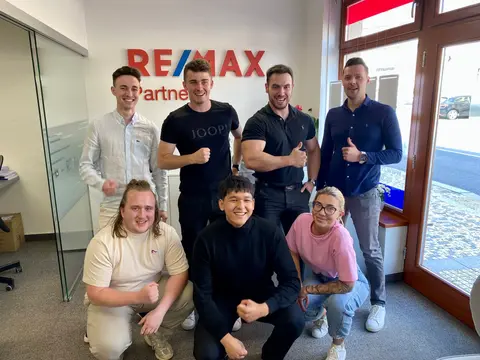 Mladá parta makléřů v kanceláři RE/MAX Partner